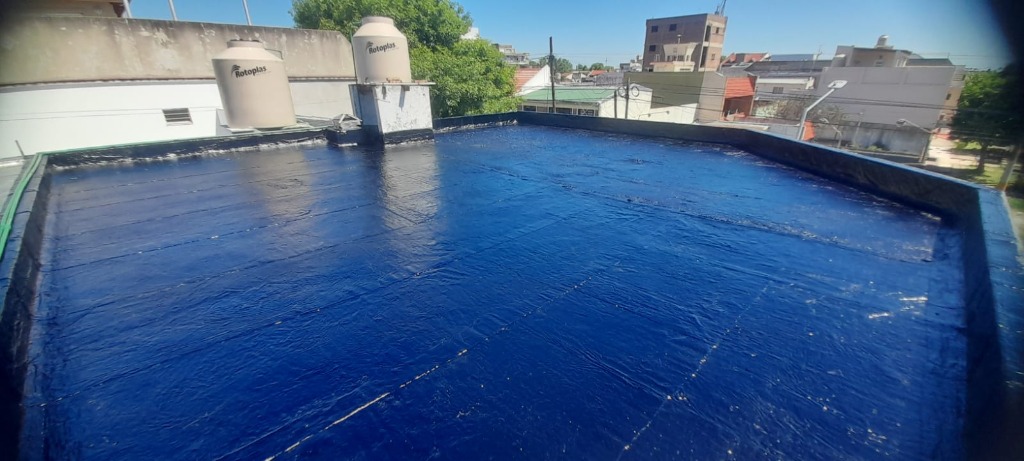 Impermeabilización líquida azúl en terraza con tanques de agua